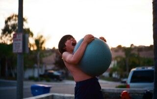 Boy Lifting Heavy Ball